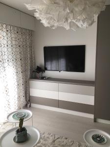 sala de estar con TV de pantalla plana en la pared en Studio Ile Cannes Marina, en Mandelieu-la-Napoule