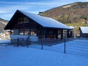 a house with a snow covered roof in the snow at Haus Margret in Mellau