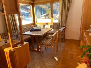 a dining room with a table and chairs and windows at Haus Margret in Mellau