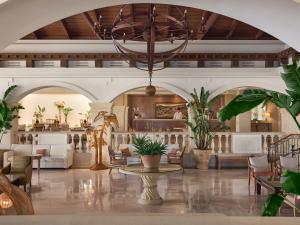 a lobby of a hotel with a table and chairs at Grecotel Marine Palace & Aqua Park in Panormos Rethymno