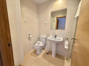 a white bathroom with a toilet and a sink at Condado de Alhama La Isla 11SV2F in El Romero +21 photos