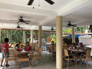 a group of people sitting at tables on a patio at Island Garden Beach Resort in Samal