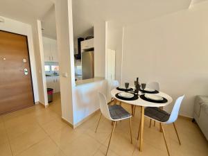 a dining table and chairs in a room with a kitchen at Condado de Alhama La Isla 11SV2F in El Romero