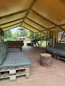 a tent with a bed and a bench and a table at Camping Les Pommiers in Comblain-au-Pont