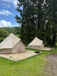 two tents sitting on a wooden deck in the grass at Camping Les Pommiers in Comblain-au-Pont +19 photos