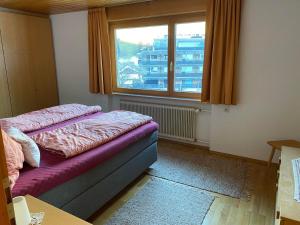 a bedroom with a bed and a window with a building at Haus Margret in Mellau +37 photos