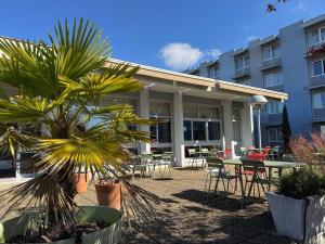 a patio with tables and chairs in front of a building at ibis Styles Angoulême Nord in Champniers