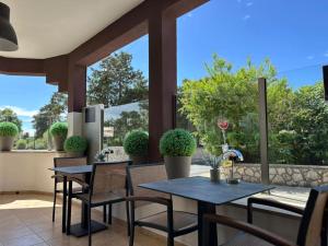 a patio with two tables and chairs and some plants at Hotel Terra Nova in Novalja