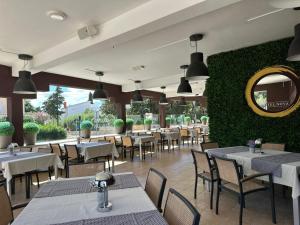 a restaurant with tables and chairs and a green wall at Hotel Terra Nova in Novalja +44 photos