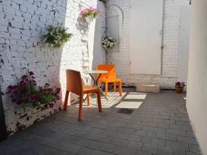 zwei orangefarbene Stühle und ein Tisch auf einer Terrasse in der Unterkunft N17 Hotel in Poltawa