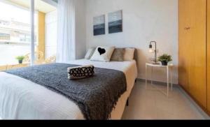 a bedroom with a large bed and a window at Acuario I RR18 in La Pineda +7 photos