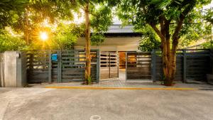 a building with a gate and two trees at Cozy & Spacious 2BR Private House in Siem Reap