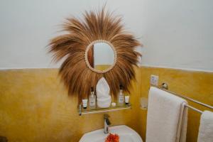 a bathroom with a mirror and a sink at Aquelia Rose Hotel in Jambiani +82 photos