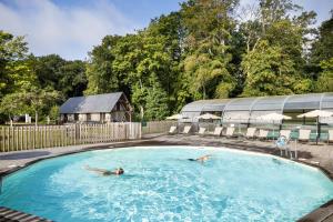 two people swimming in a swimming pool at Huttopia Calvados - Normandie in Moyaux
