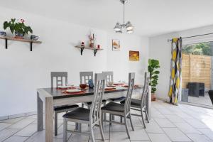 a dining room with a wooden table and chairs at L'Estran qu'Île - Proche plages in LʼÎle-dʼOlonne