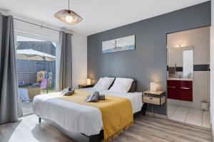 a bedroom with a large bed with a yellow blanket at L'Estran qu'Île - Proche plages in LʼÎle-dʼOlonne