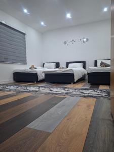 two beds in a room with a rug at Family Private House w Garden & Gazebo 10 Guests in Sarajevo