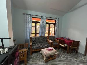 a living room with a table and a chair and a window at Jasmine Guest House in Majorda