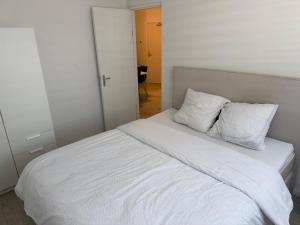 a white bed with two pillows on top of it at Casaejon in Lelystad