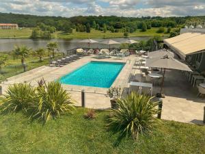 an overhead view of a swimming pool with chairs and umbrellas at Novotel Limoges Le Lac in Limoges