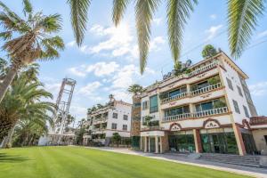 a building with palm trees in front of it at Jeju Nine resort in Jeju