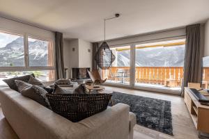 a living room with a couch and large windows at Amselfluh in Arosa