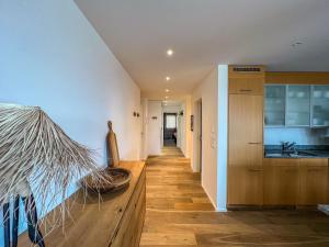 a hallway of a home with a kitchen with a wooden floor at Amselfluh in Arosa +7 photos