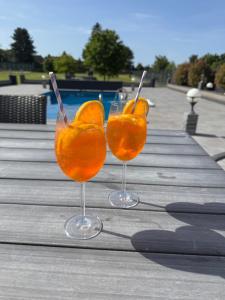 two glasses of orange juice on a wooden table at Premium Apartment near Cologne in Hürth +6 photos