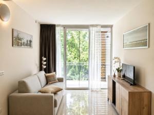 a living room with a couch and a tv at Apartment Mare45 - 10 minutes walk from the beach with one private ombrella and three sun-beds in Eraclea Mare
