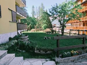 a yard with a fence next to a building at Appartamento La Primula in Madesimo