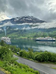 two cruise ships on the water with a mountain at Olden house fjord and sunset in Stryn
