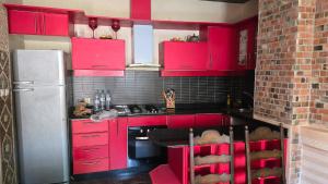 a red kitchen with red cabinets and a refrigerator at Appement in Agadir nʼ Aït Sa