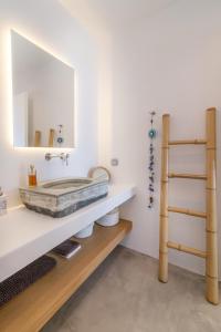 a bathroom with a sink and a mirror at Tinos Prinos 3 in Agios Fokas +10 photos