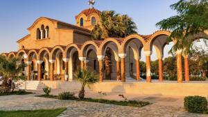 a church with palm trees in front of it at Forest Calm Faliraki in Faliraki