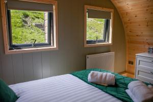 a bedroom with two windows and a bed in it at Calmwater Hideaway in New Hey