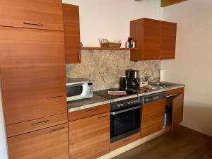 a kitchen with wooden cabinets and a microwave at Landhaus Löscher in Seeboden +23 photos