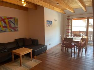 a living room with a couch and a table and chairs at Landhaus Löscher in Seeboden