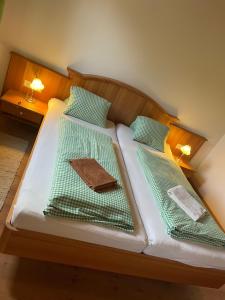 two beds with green and white sheets and pillows at Landhaus Löscher in Seeboden