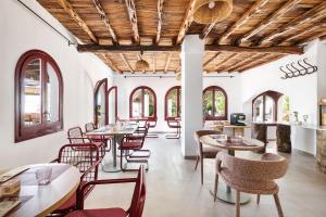 a restaurant with tables and chairs and windows at One Shot Buenavista in Santa Eularia des Riu