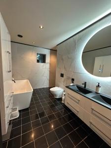 a bathroom with a tub and a toilet and a sink at Olden house fjord and sunset in Stryn