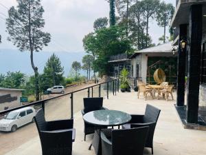a patio with tables and chairs on a balcony at Hestia by Gunner Lodges in Patriata