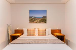 a bedroom with a large bed with two night stands at CASA MIA - Luxury Apartments Central Kuta in Kuta Lombok