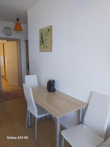 a dining room with a table and white chairs at Апартамент Нина in Byala +16 photos