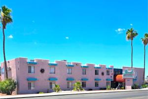a hotel with palm trees in front of a building at Sands Inn & Suites Lake Havasu City in Lake Havasu City