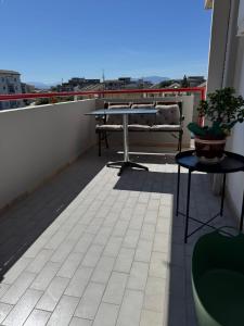 a balcony with a table and benches on a roof at Domus Relax in Battipaglia +11 photos