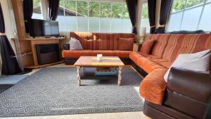 ein Wohnzimmer mit Sofa und Couchtisch in der Unterkunft Mobilehome in Weissenburg