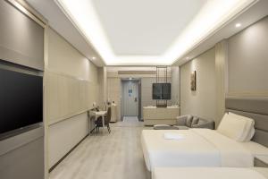 a hotel room with two beds and a television at Atour Hotel Hotan Unity Plaza in Hoten