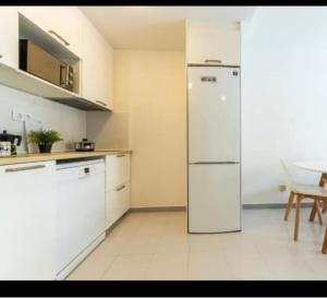 a kitchen with a white refrigerator and a table at Acuario I RR18 in La Pineda