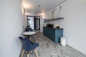 eine Bar mit blauen Stühlen und einem Tisch in einem Raum in der Unterkunft N17 Hotel in Poltawa
