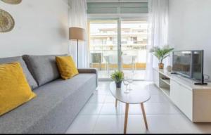 a living room with a gray couch and a table at Acuario I RR18 in La Pineda